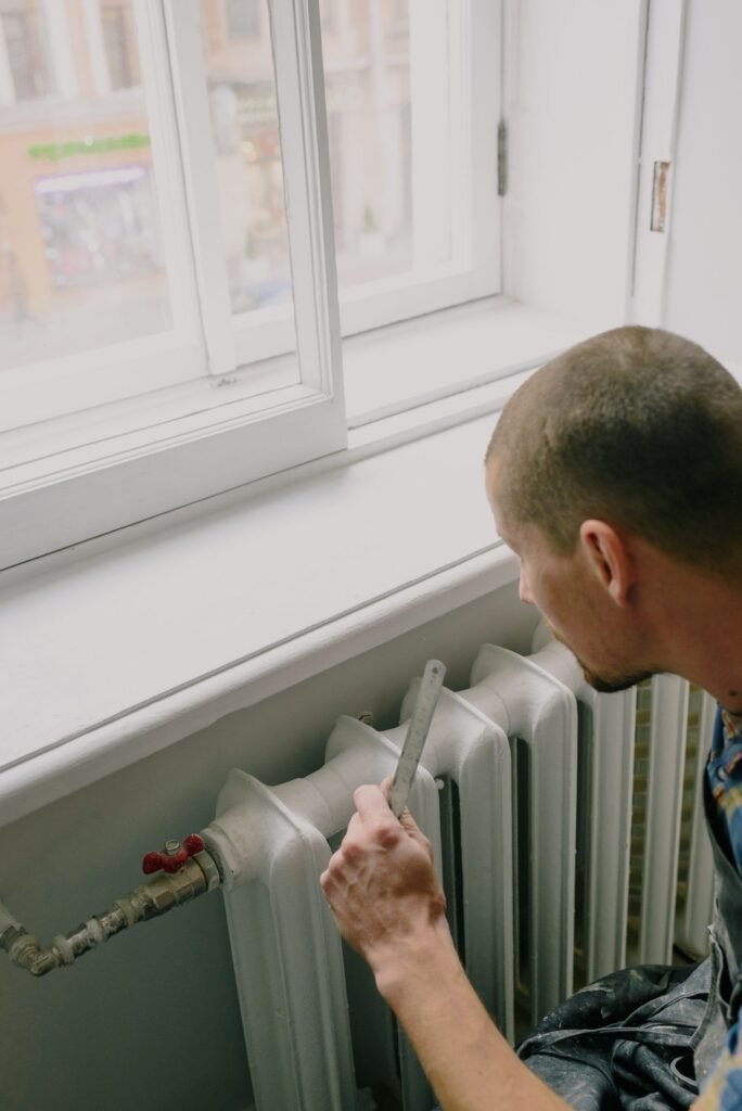 Technicien prenant des mesures près d'un radiateur